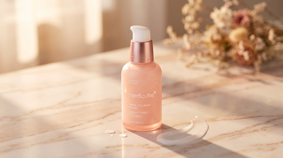 Medicube Triple Collagen Serum 4.0 бутилка на розово-бежова мраморна повърхност